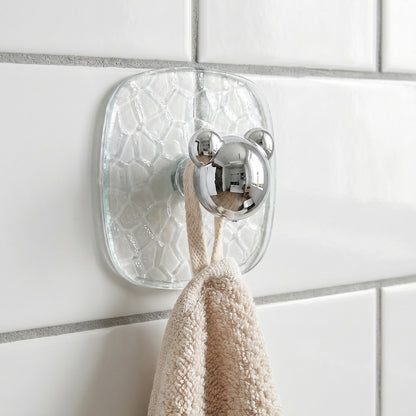 Close-up of clear plastic adhesive wall hook holding a kitchen towel
