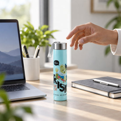 A hand reaching for a small light blue water bottle on a desk with a laptop and notebook.