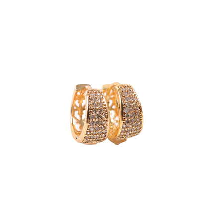 Wide huggie gold hoop earrings sparkling under light for festive occasions