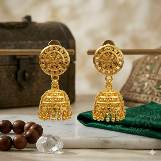 Close-up of gold tone jhumka earrings with intricate design