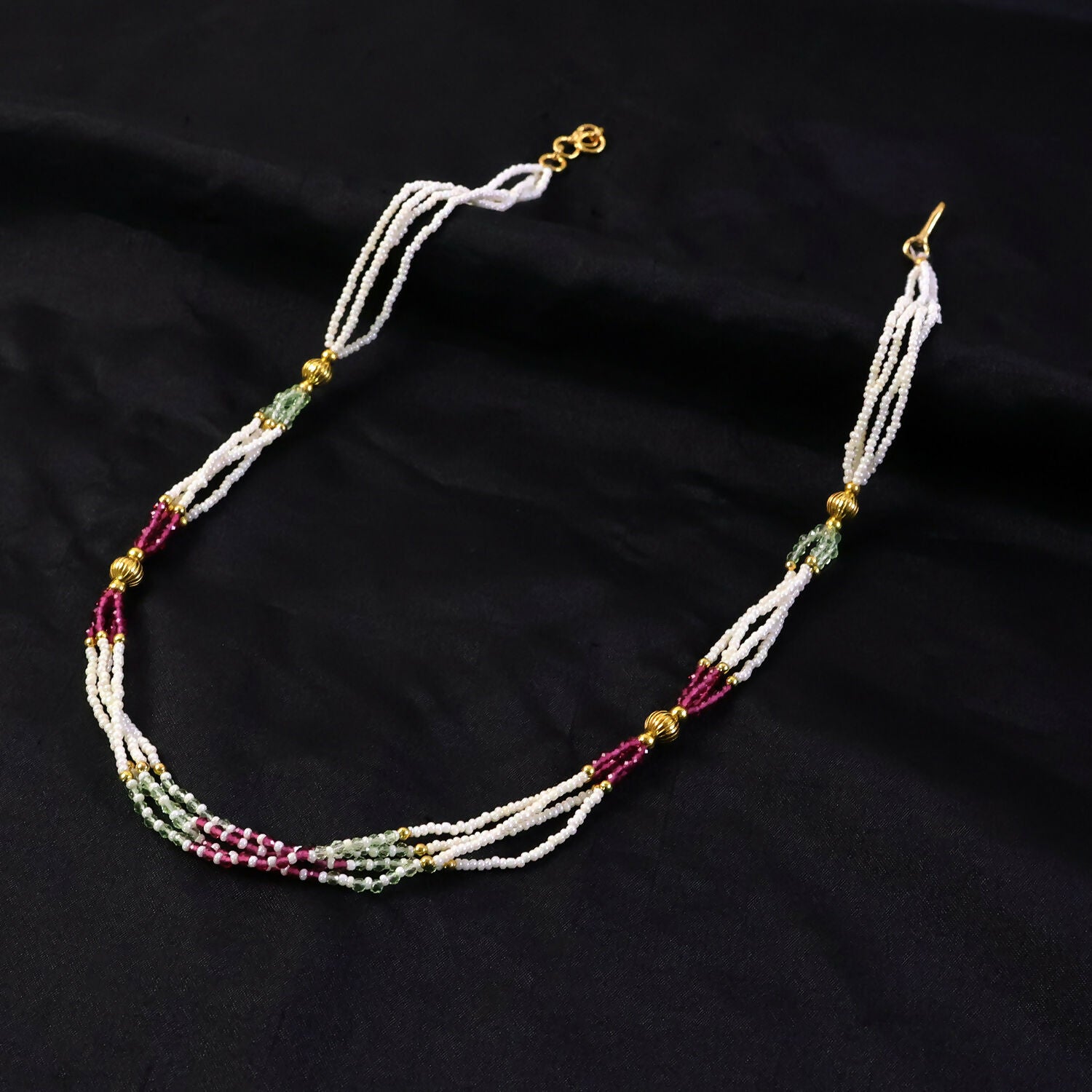 Close-up of pearl beads with dual-tone pink and mint accents on mala necklace