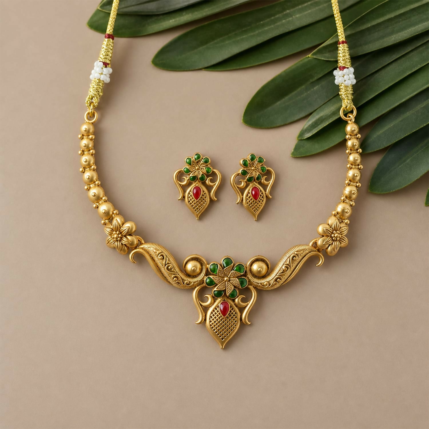 Detailed shot of one matching earring from the antique necklace set, featuring floral motifs and stone work.