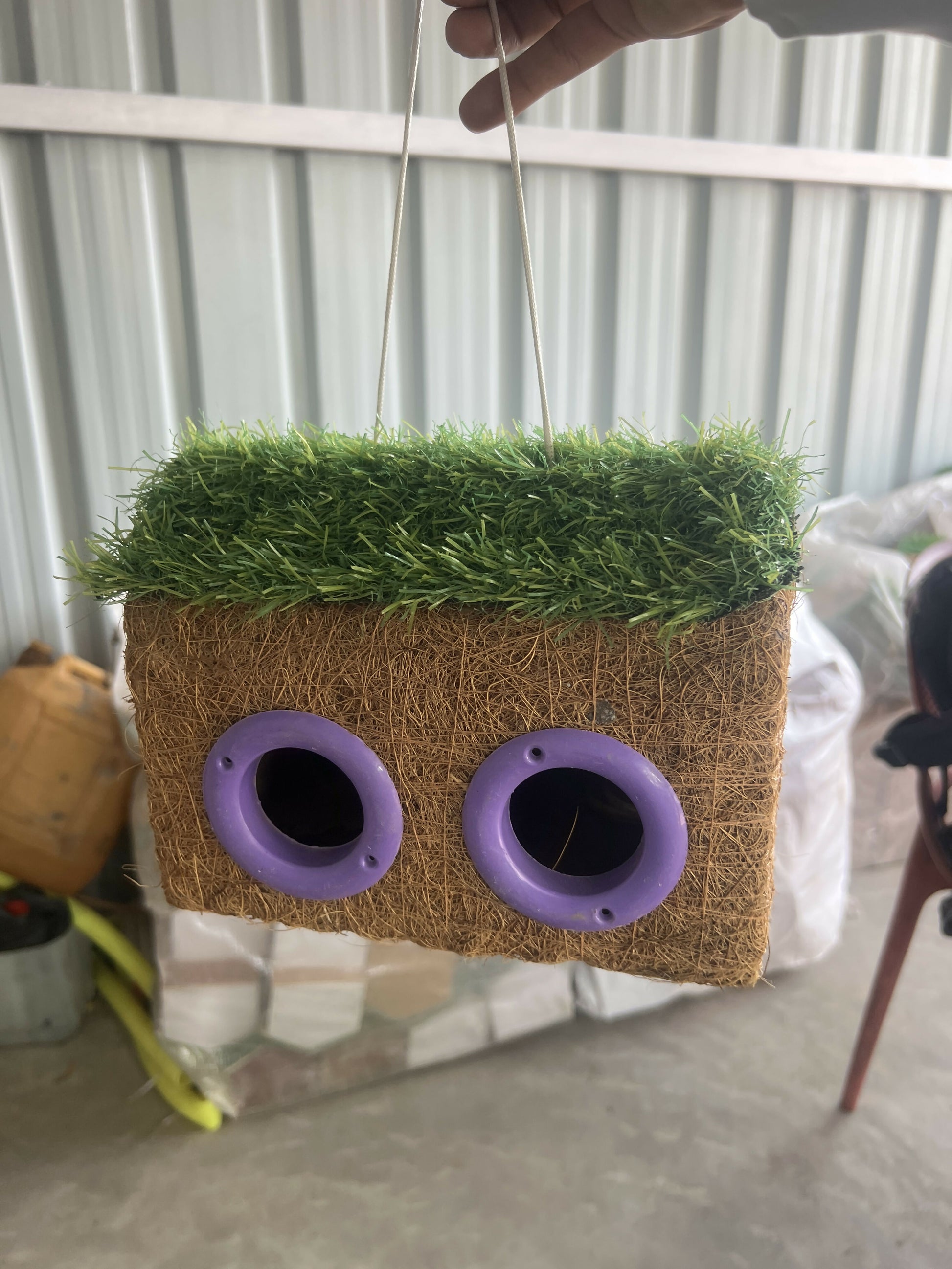 Close up of dual-entry nesting holes on coir bird house