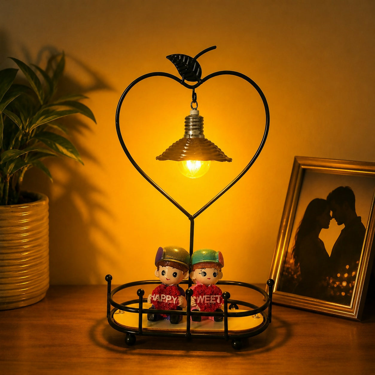 Close-up of romantic couple sitting figurines on table lamp