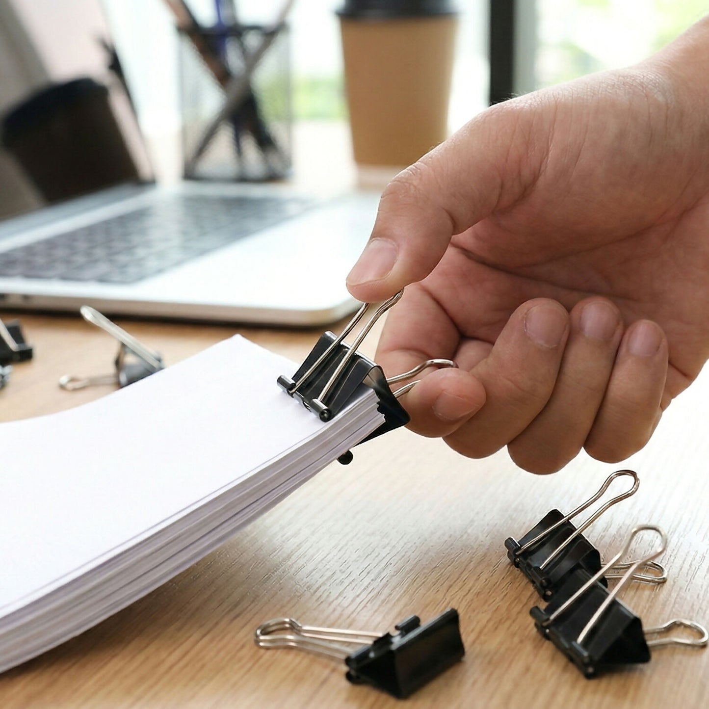 Close-up of 19mm black binder clip holding papers