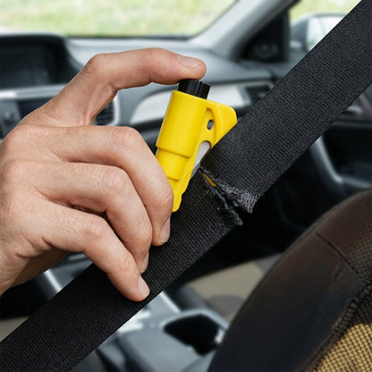 A hand uses a yellow car safety hammer to cut a black seat belt, which is partially frayed from the action, inside a car.