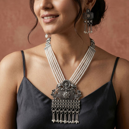 Close-up of ornate pendant in gold with pearl accents
