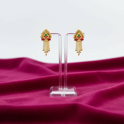 Side angle of golden jhumka earrings highlighting delicate latticework and enamel accents