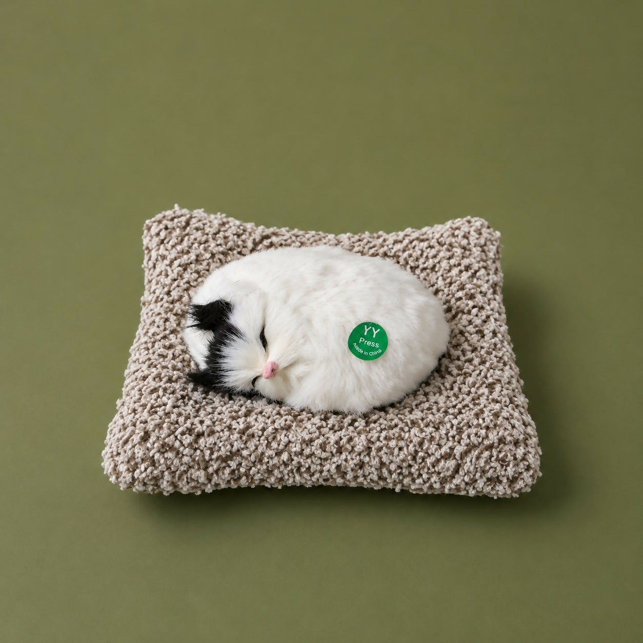 Side view of sleeping cat plush with cozy cushion base