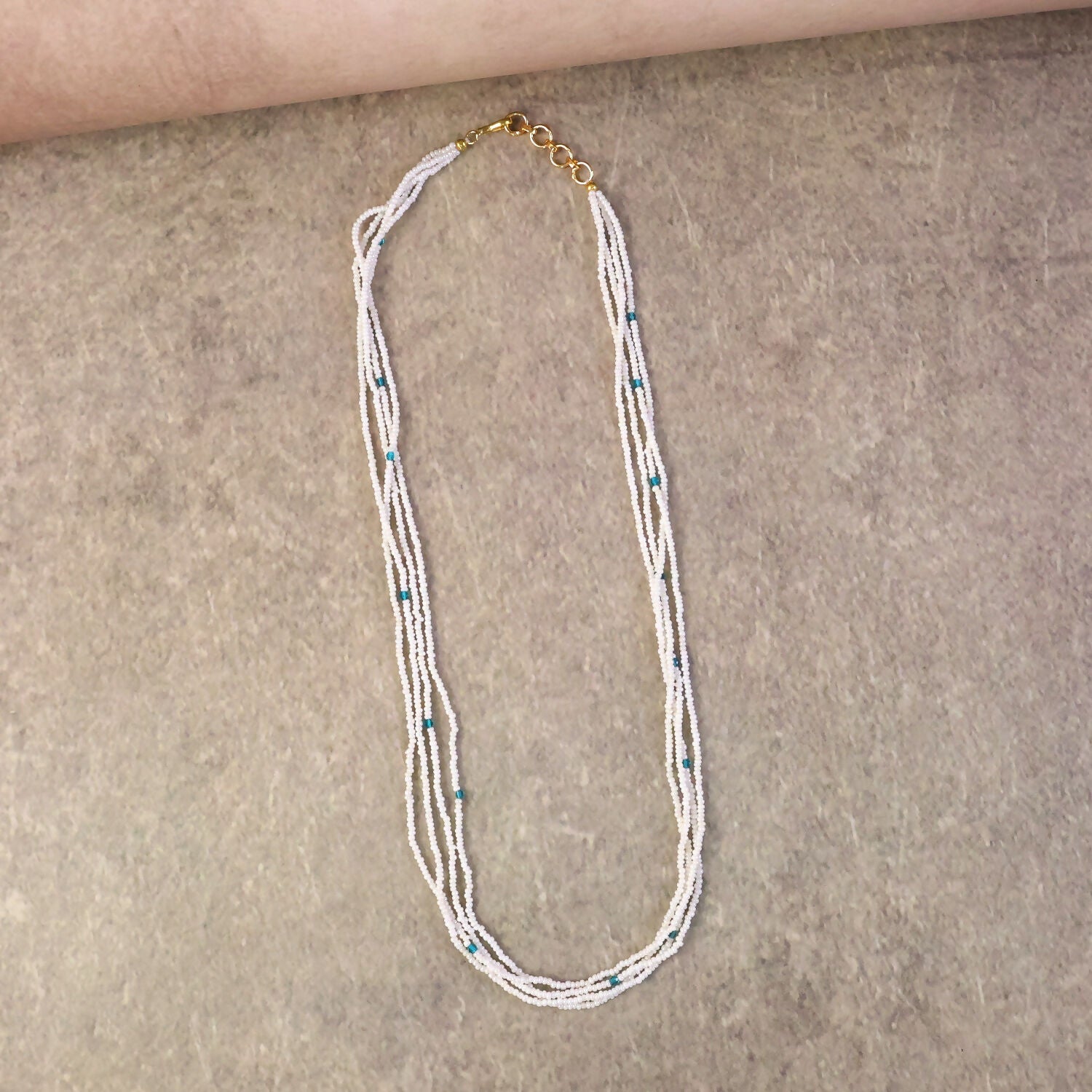 Close-up of pearl mala necklace showing detailed blue accents and layers