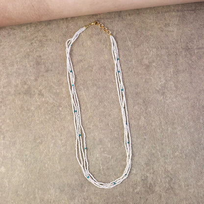 Close-up of pearl mala necklace showing detailed blue accents and layers