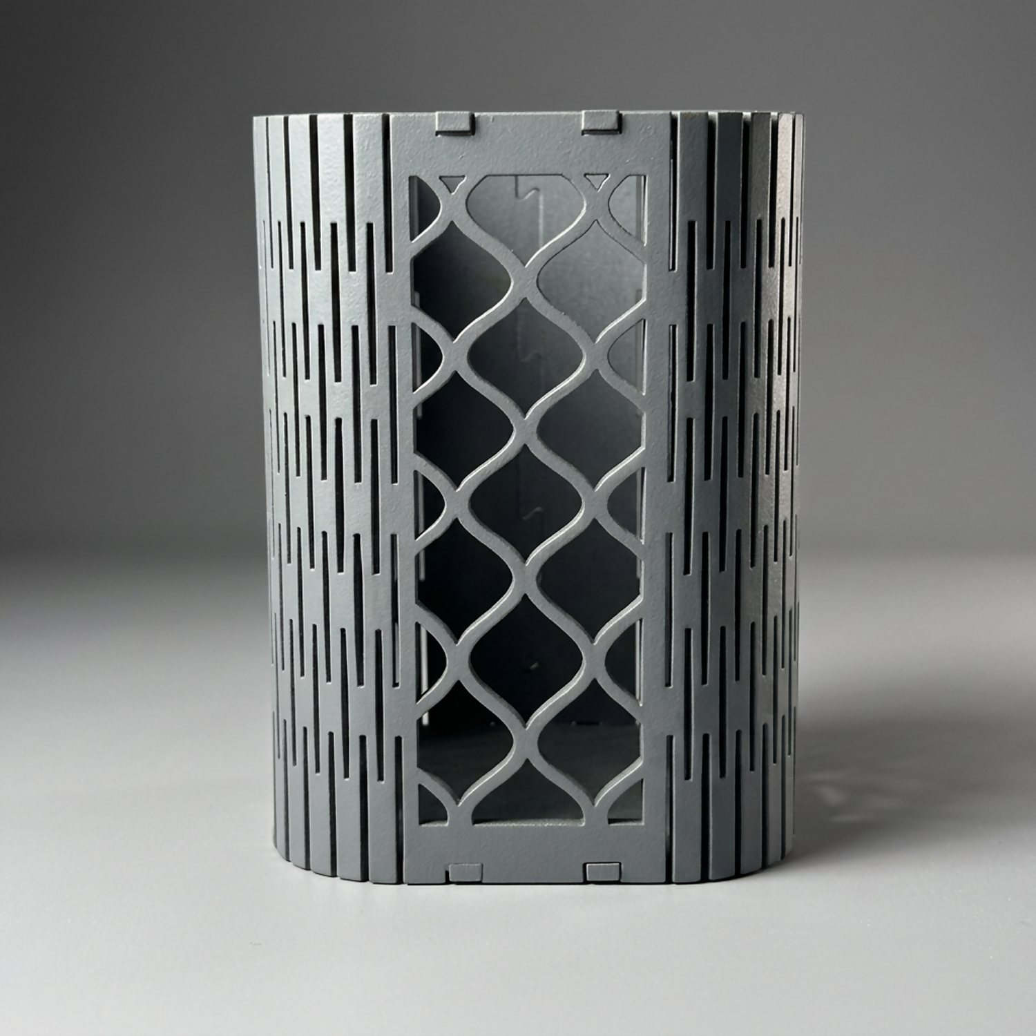 Elegant geometric mesh pen holder on a wooden desk with other office essentials.