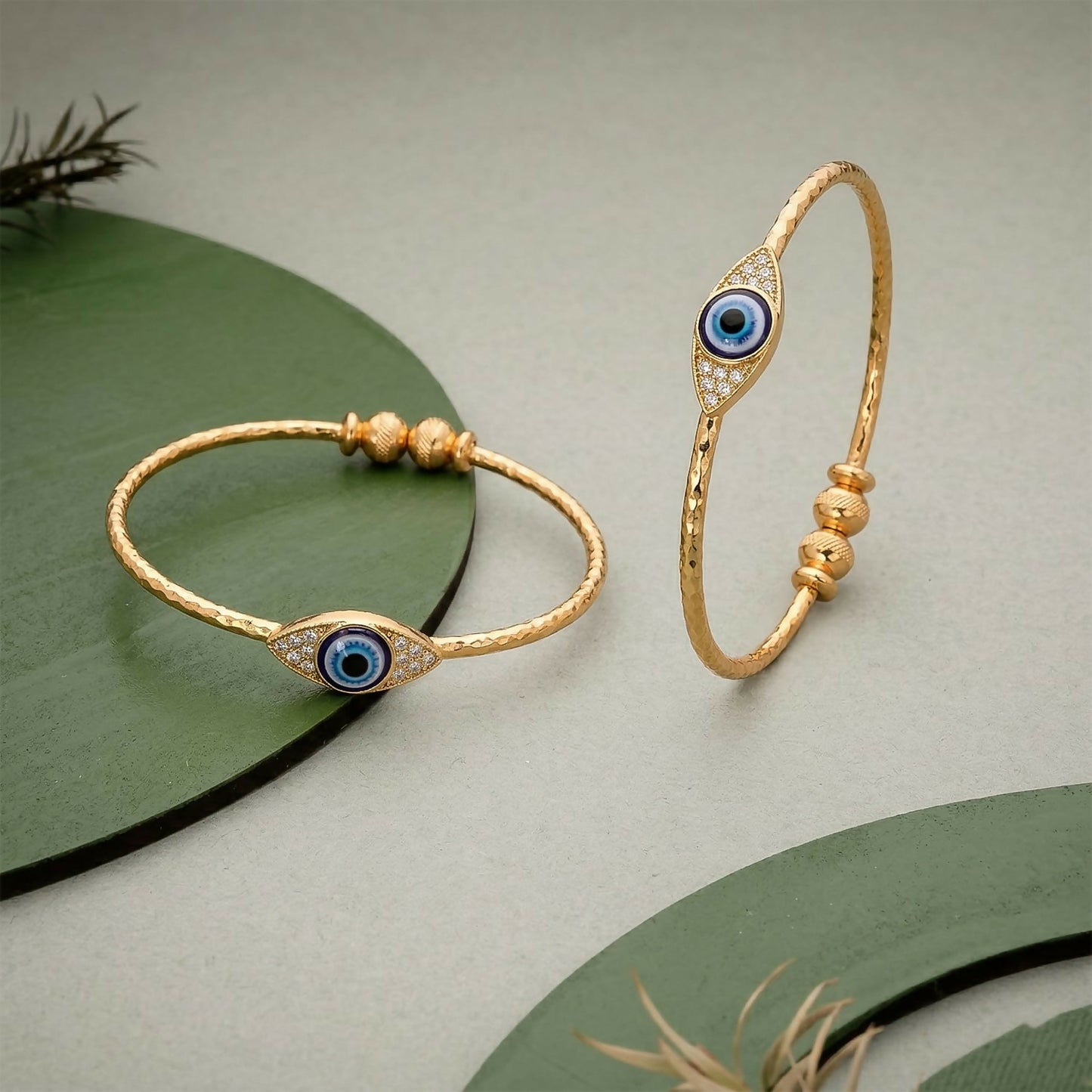 Side view of gold evil eye bangle with adjustable bead closure
