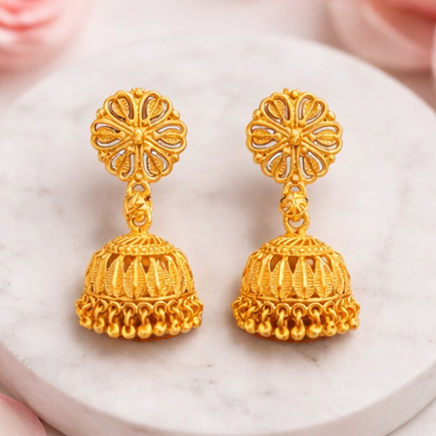 Close-up of gold plated jhumka earrings with traditional intricate design