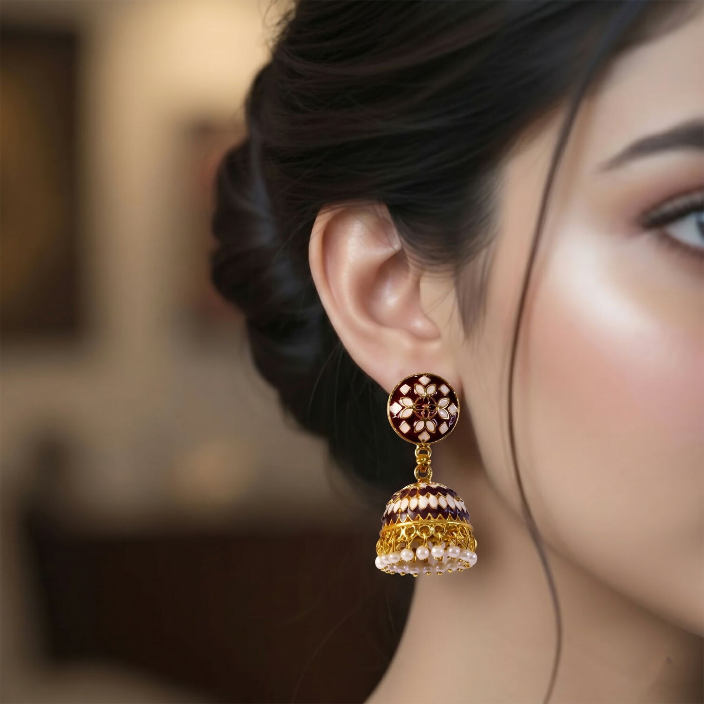 Close-up of golden detailing on maroon jhumka earrings