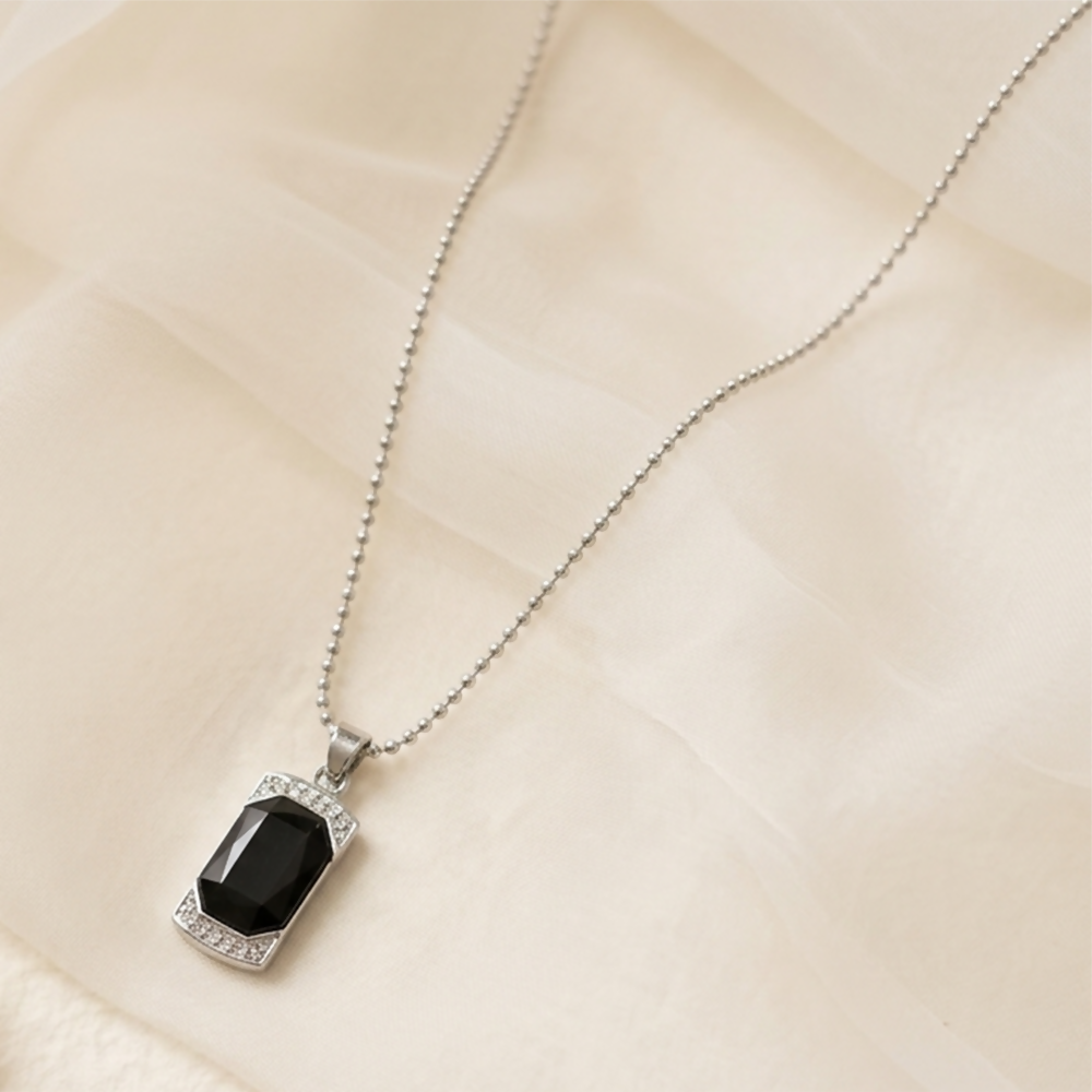 Elegant black onyx pendant necklace with crystal frame on white background