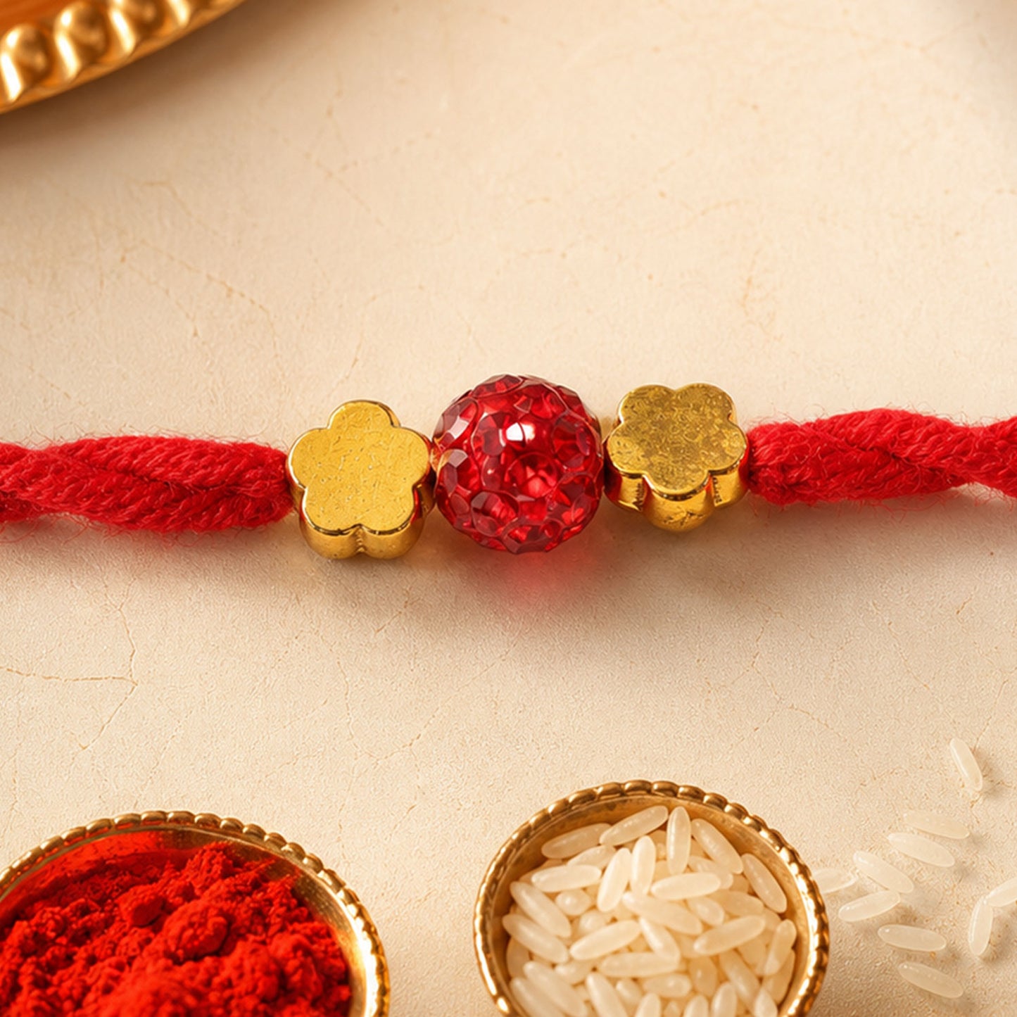 Red Thread Rakhi with Sparkling Red Ball Bead and Gold Flower Accents
