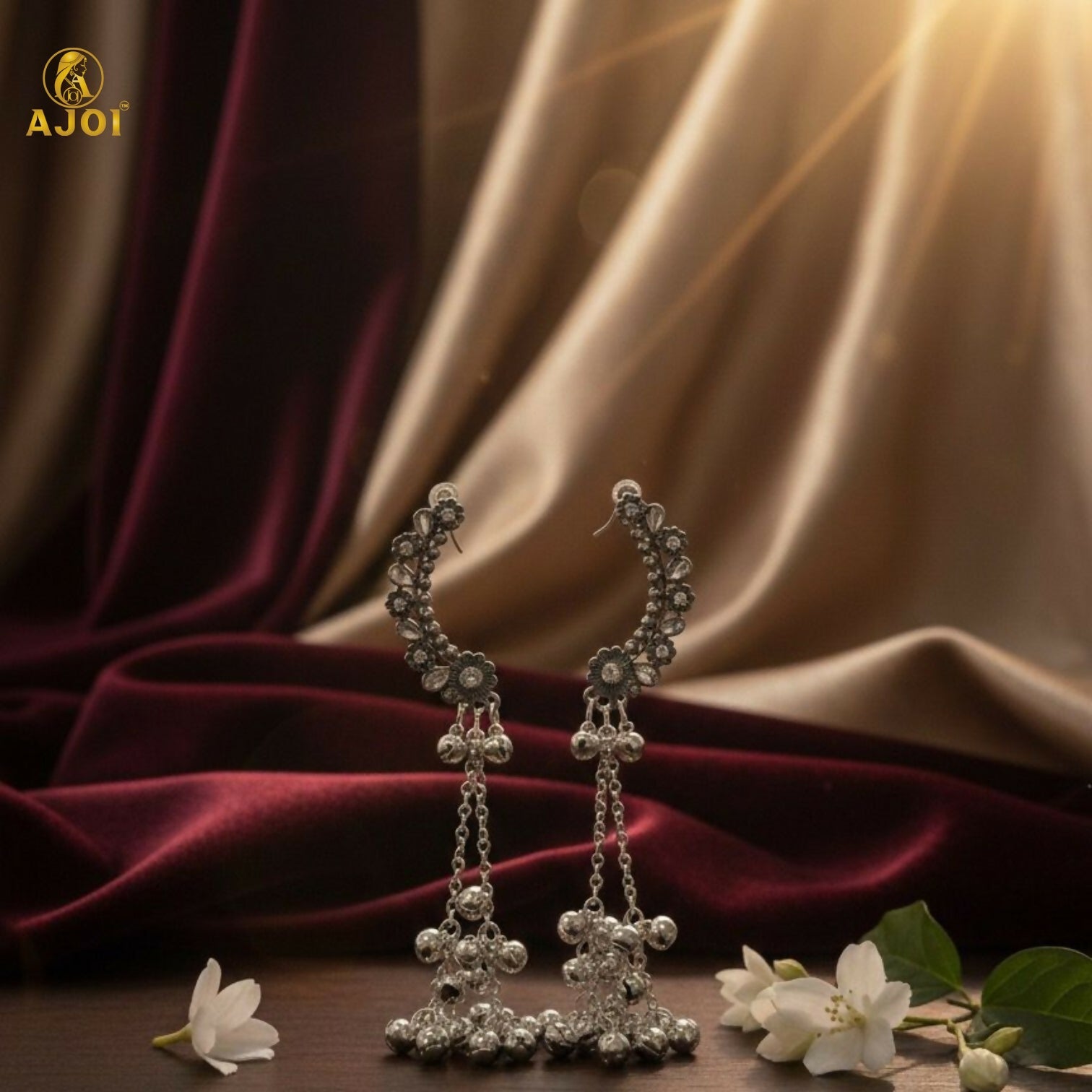 Pair of silver Chandbali jhumka earrings displayed on white background