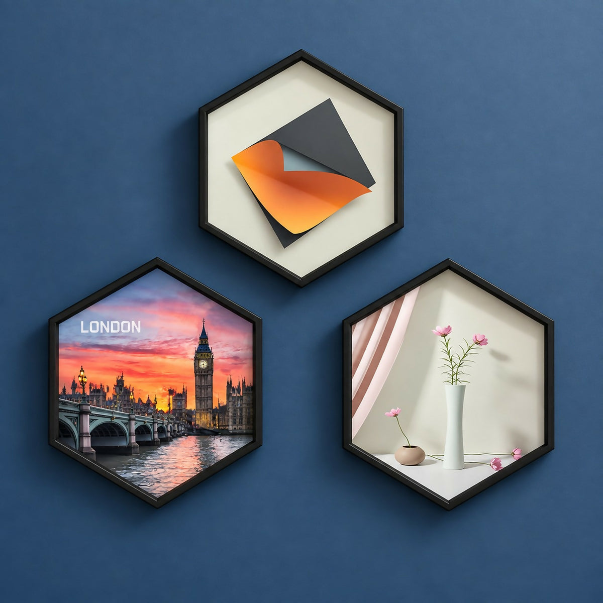 Three black hexagon frames on a blue wall, one with London cityscape, one with abstract art, one with a vase and flowers.