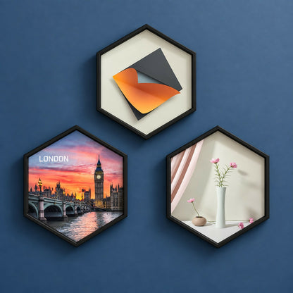 Three black hexagon frames on a blue wall, one with London cityscape, one with abstract art, one with a vase and flowers.