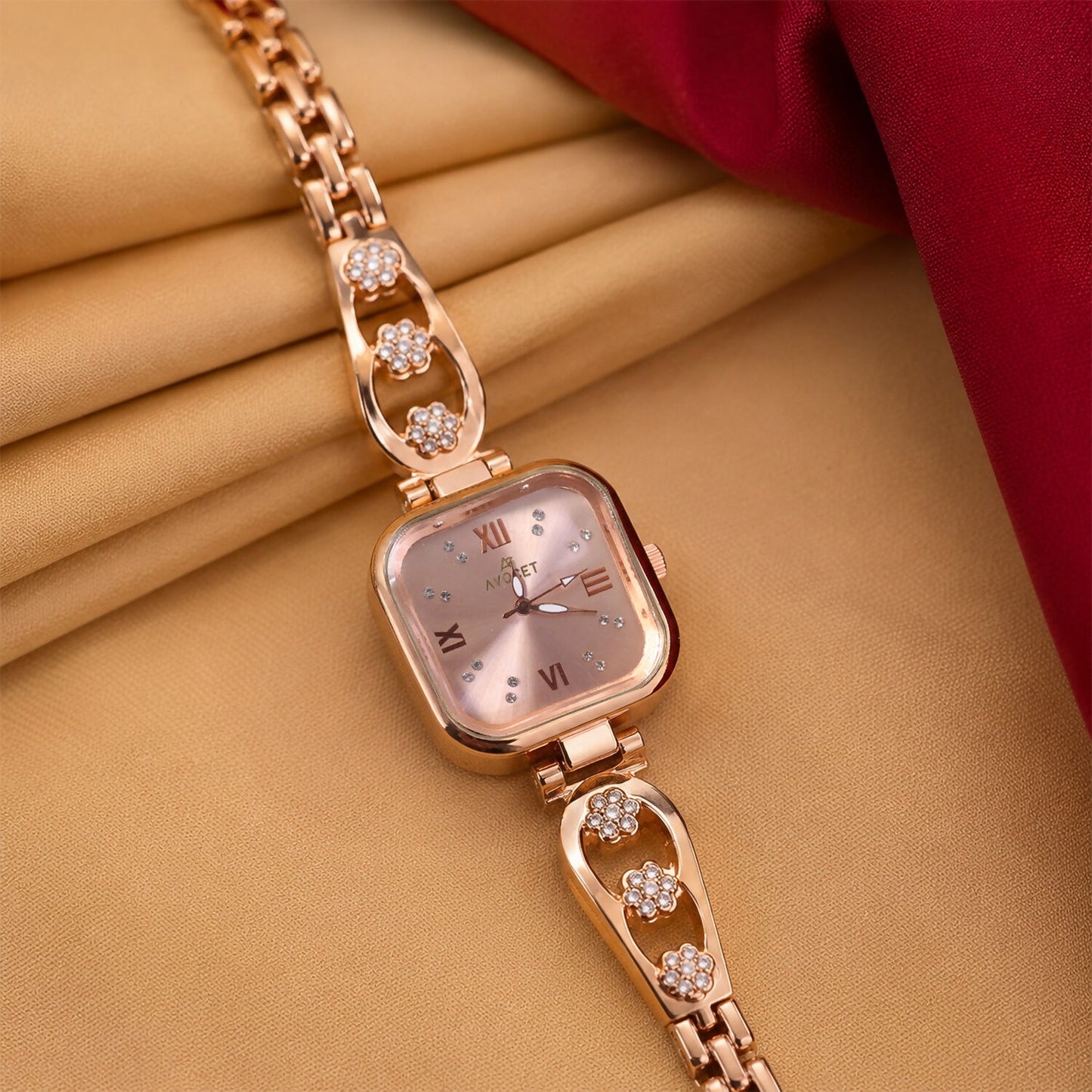Elegant women's rose gold square dial watch with a floral metal bracelet.