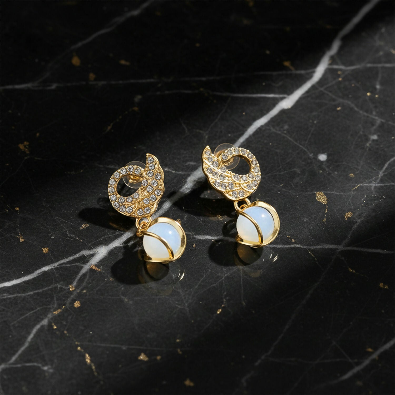 Swan earrings displayed on jewelry stand with light reflections