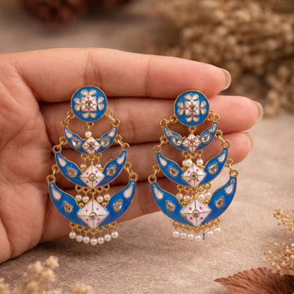 Close-up of meenakari and pearl details on royal blue earrings