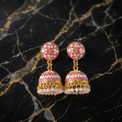 Side view of pink round stud jhumka earrings with pearl accents