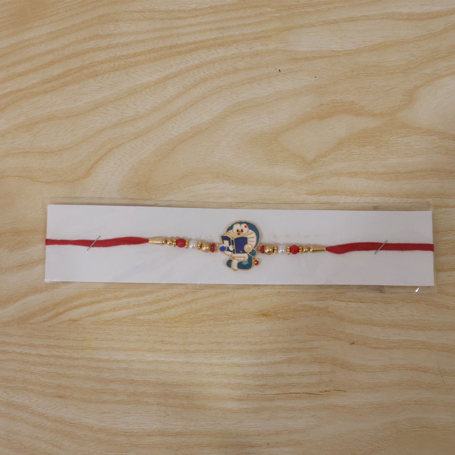 Doraemon Kids Rakhi with Red Gold Beads and Playful Blue Charm