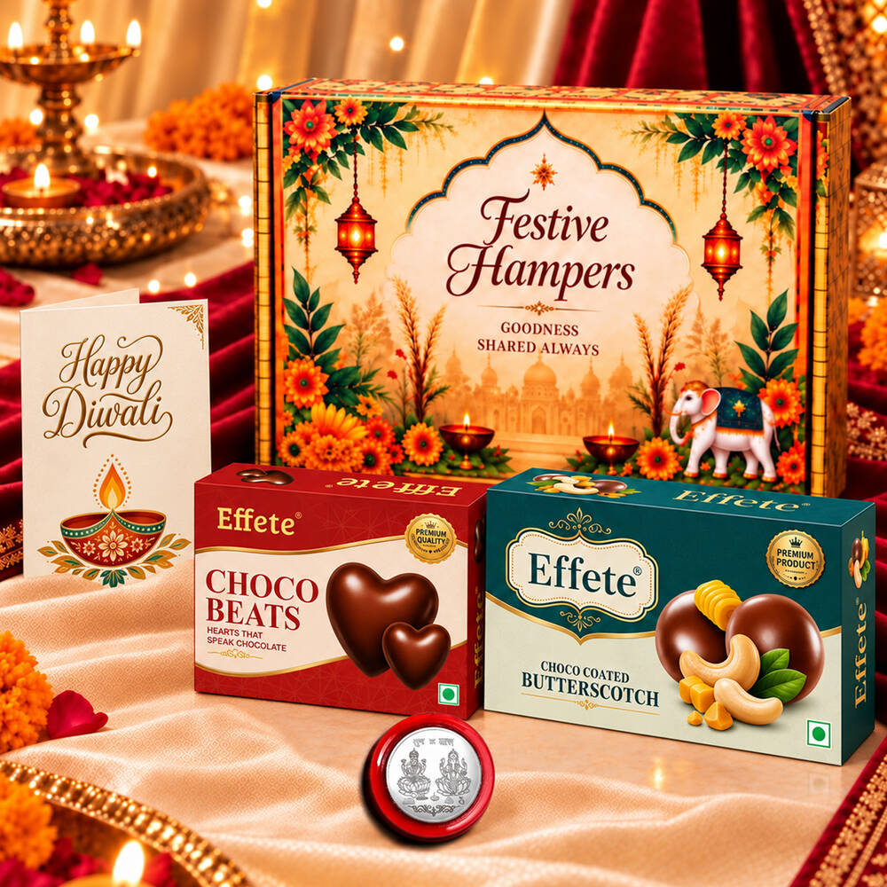 A festive hamper box with two Effete chocolate boxes, a silver coin, and a Happy Diwali card on a white cloth.