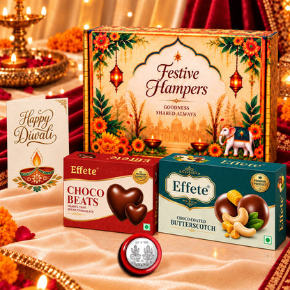 A festive hamper box with two Effete chocolate boxes, a silver coin, and a Happy Diwali card on a white cloth.