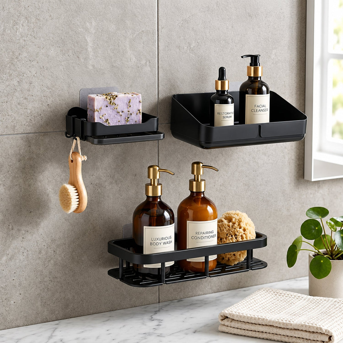 Three black plastic shower caddies with assorted bath products and a small green plant on a grey tiled wall.