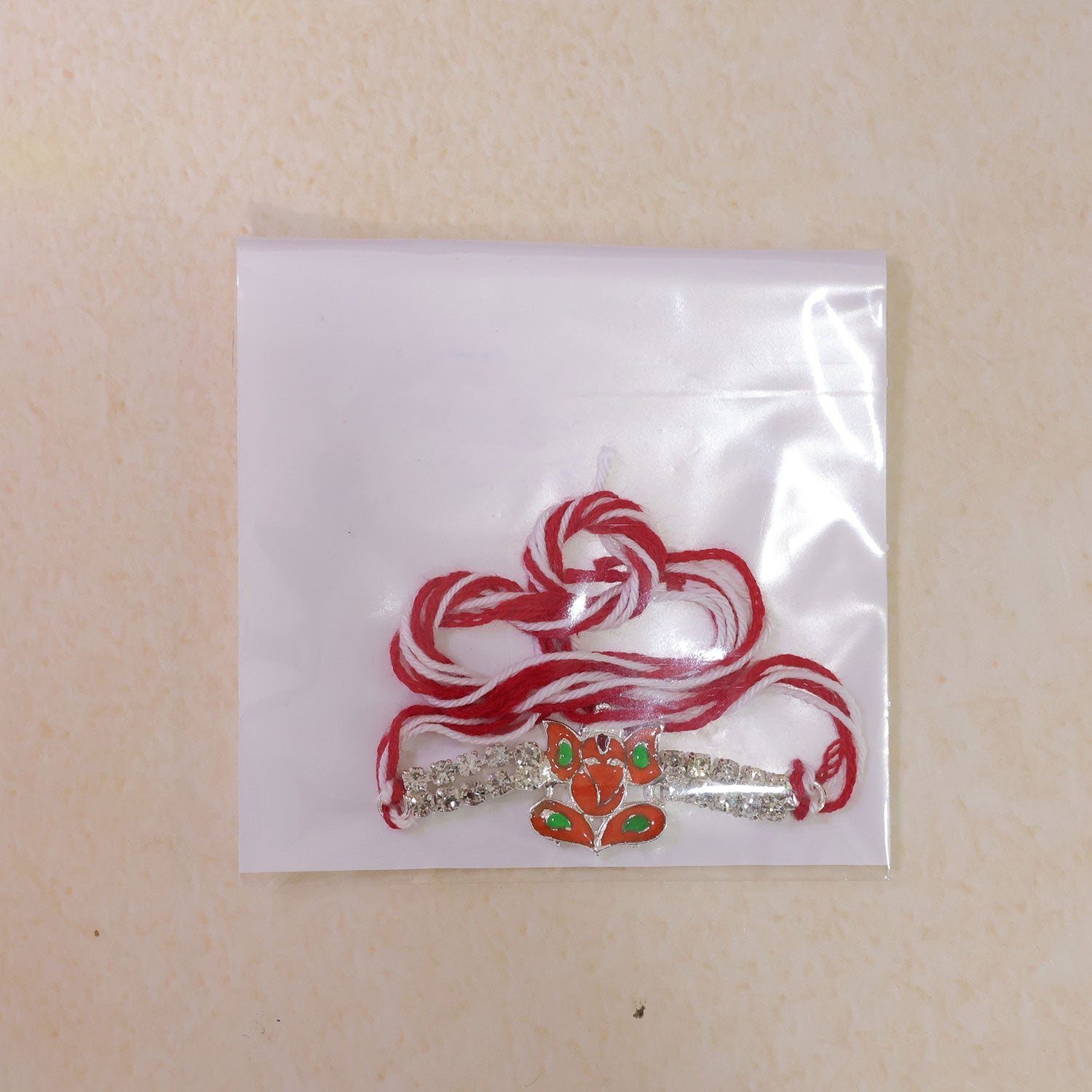 Silver-Toned Lord Ganesha Rakhi with Orange-Green Enamel, Double Crystal Chain & Red Thread