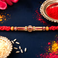 Red Braided Rakhi with Wooden Beads and a Pink Crystal Cylinder Bead