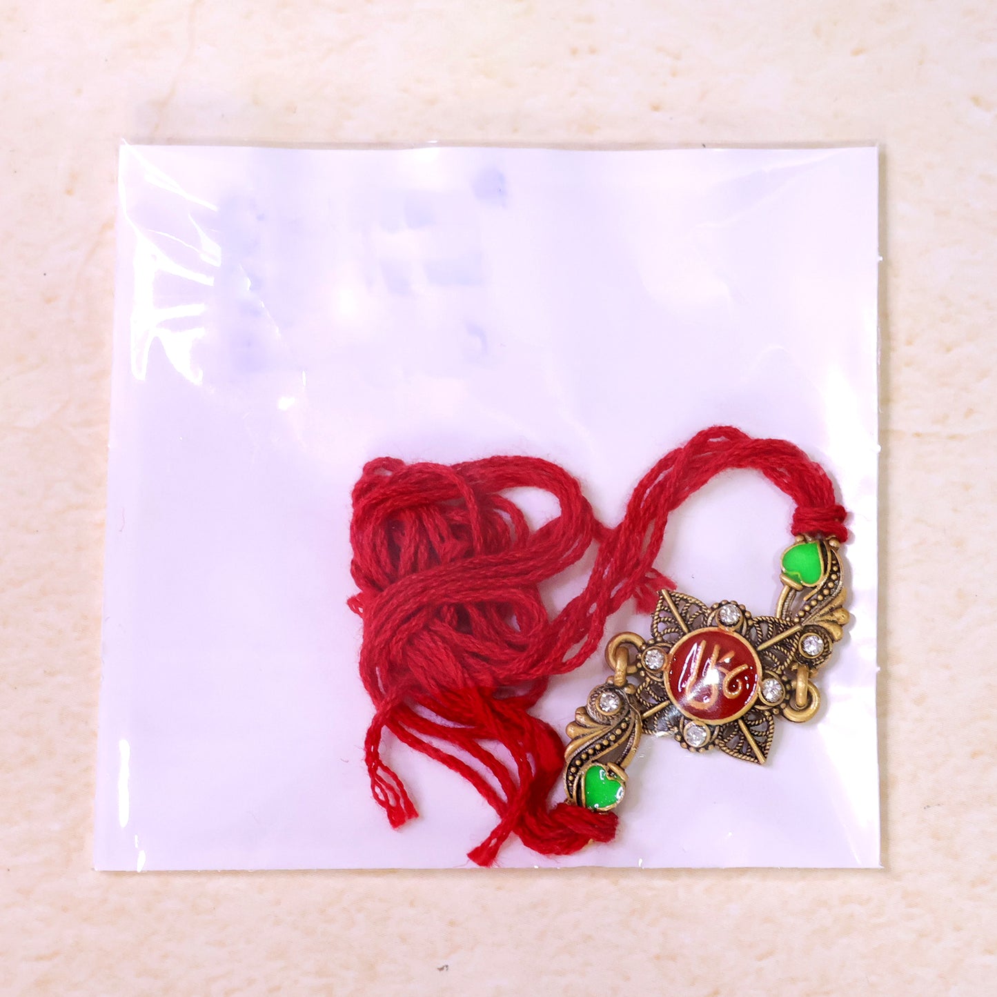 Antique Gold-Toned Shree Rakhi with Crystal Accents, Green Enamel & Designer Red Thread