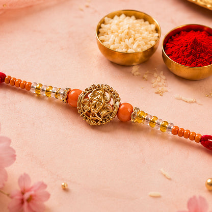 Lord Ganesha Golden Devotional Rakhi with Orange Beads and Crystal Highlights
