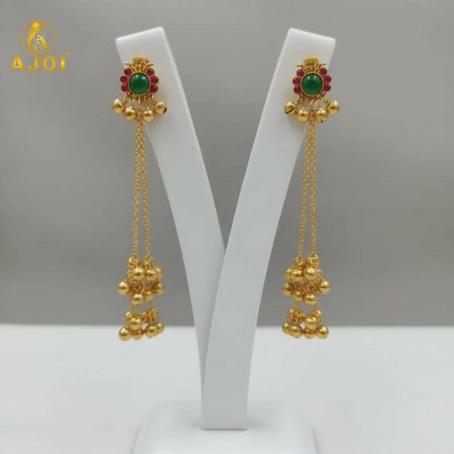 Close-up of emerald center stone and ruby accents on gold-plated Kashmiri earrings