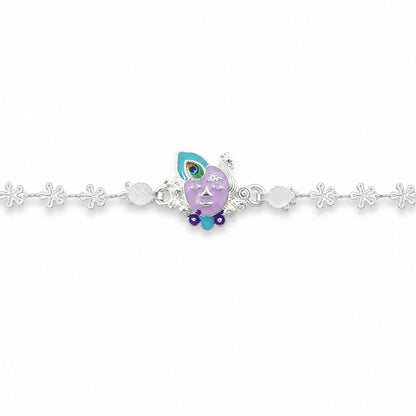The silver rakhi with a purple enamel Krishna face charm laid flat against a plain white background.