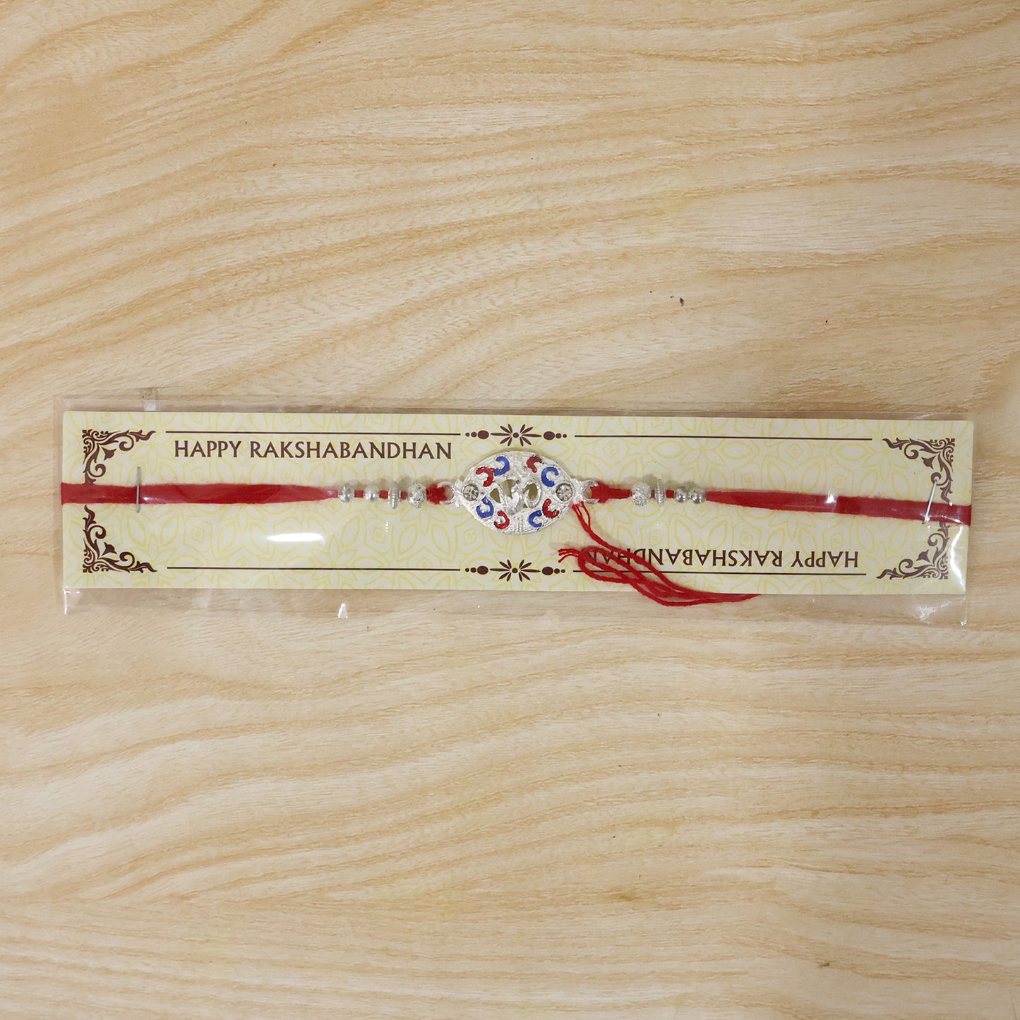 Silver Om Rakhi for Boys with Red Thread and Colorful Accents