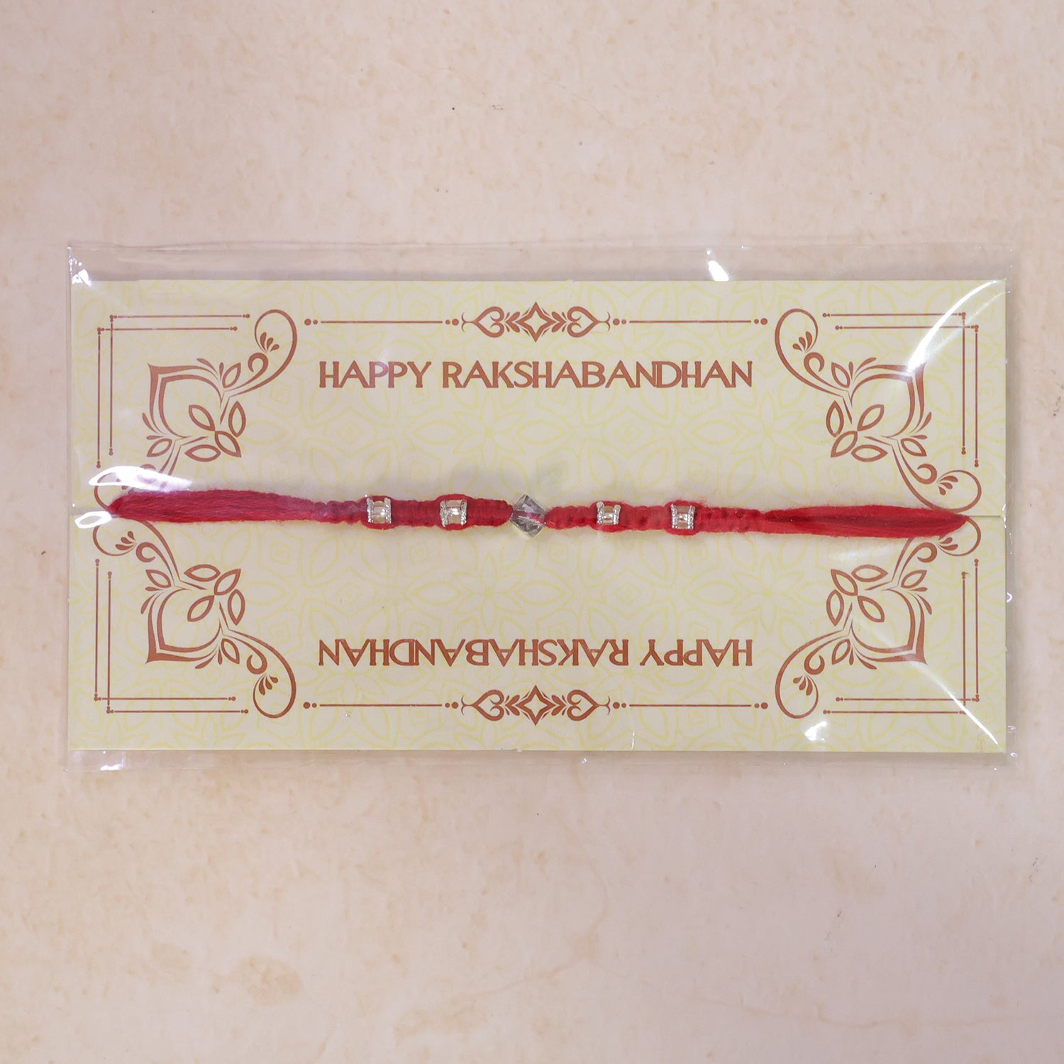 Red Thread Rakhi with Silver Square Beads and Diamond-Shaped Charm