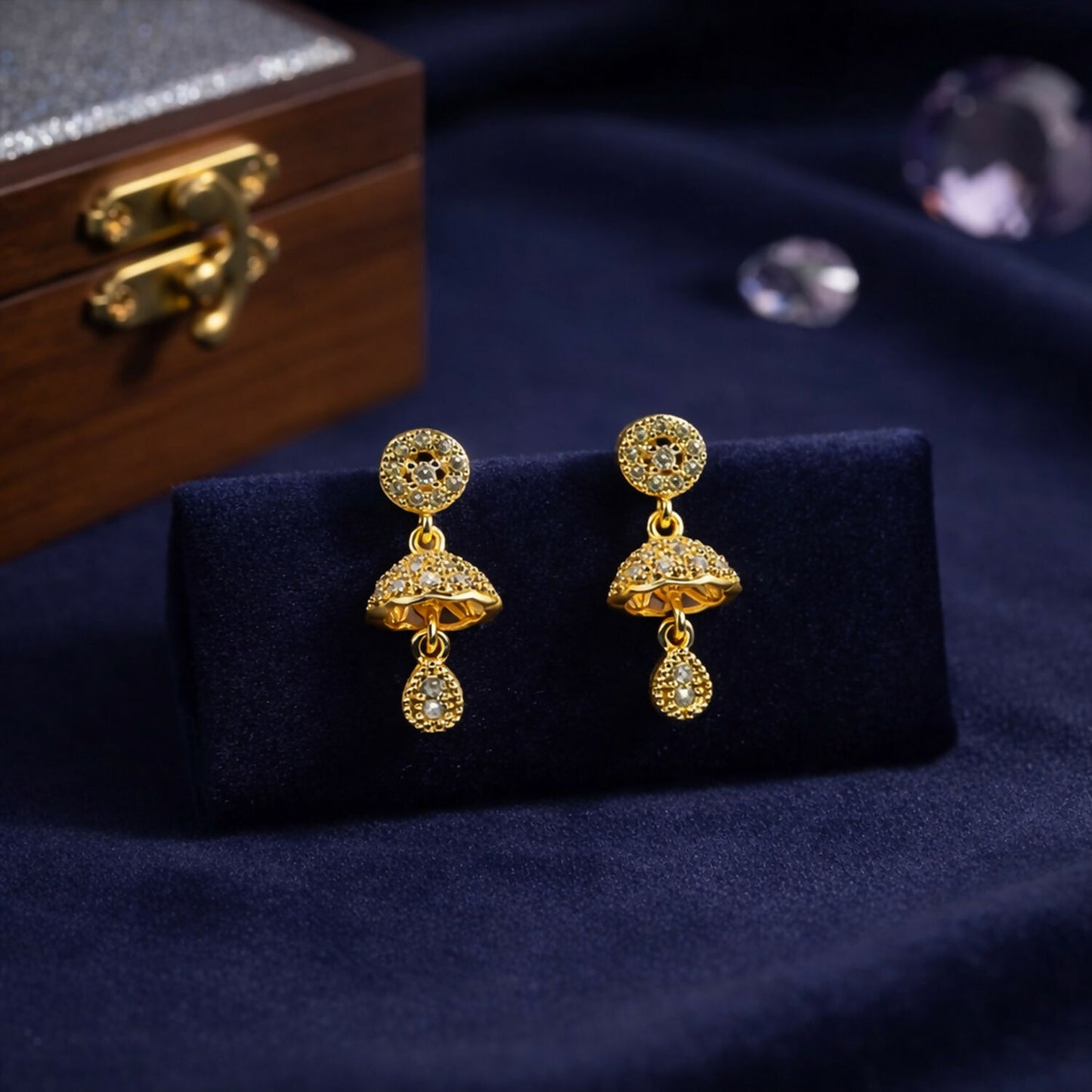Side view of gold-tone floral dome earrings featuring shimmering stones and teardrop charm