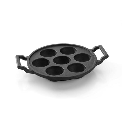 Cast iron appam pan on gas stove with snacks cooking