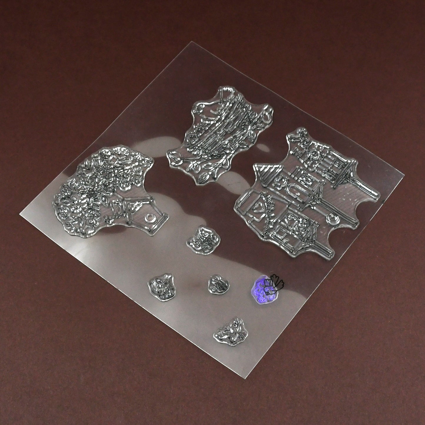 A clear rubber stamp sheet with various nature-themed designs is shown on a brown surface.