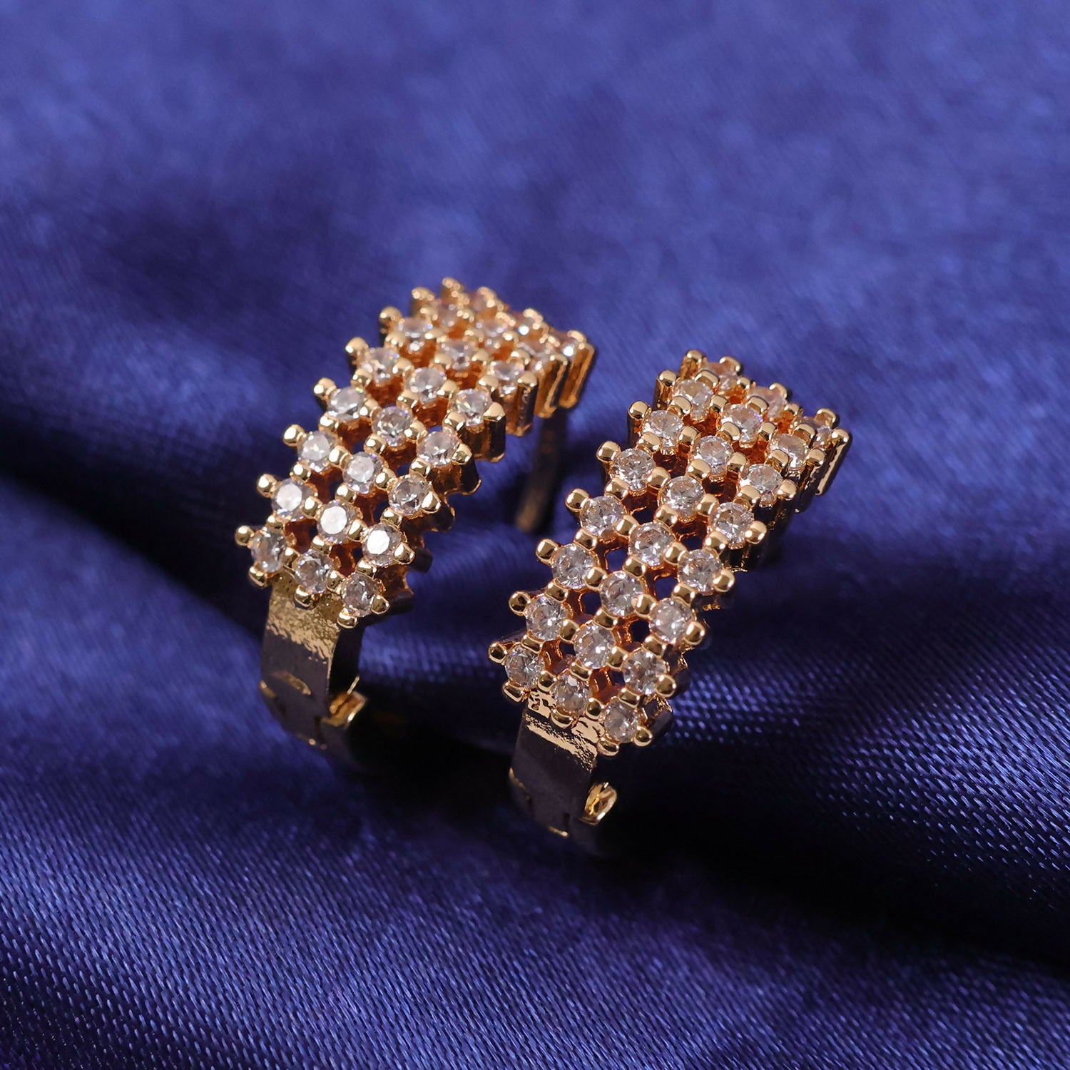 Side angle showing structured design of gold-tone CZ hoop earrings