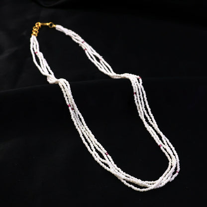 Detailed shot of pink accent beads on a layered pearl mala necklace