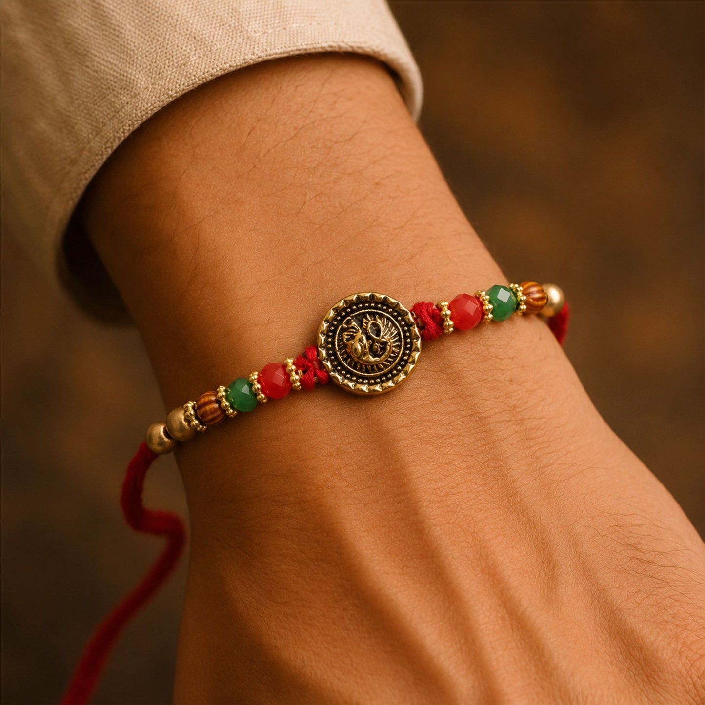 Ganesha Golden Medallion Devotional Rakhi with Red Green Beads and Festive Thread