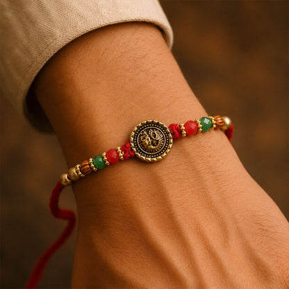 Ganesha Golden Medallion Devotional Rakhi with Red Green Beads and Festive Thread