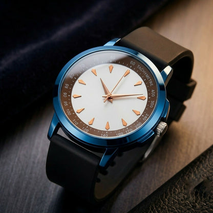 A blue watch with a white dial, gold hour markers, and a black strap rests on a dark, textured background.