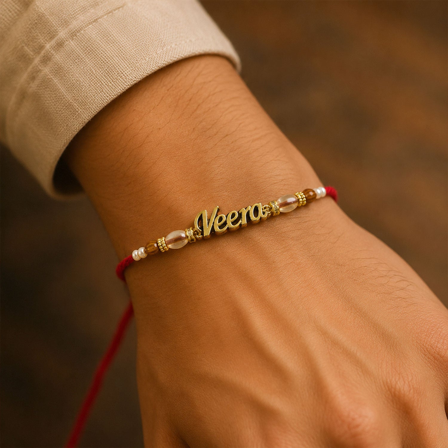 Veera Name Golden Rakhi with White Brown Beads, Red Thread and Premium Finish