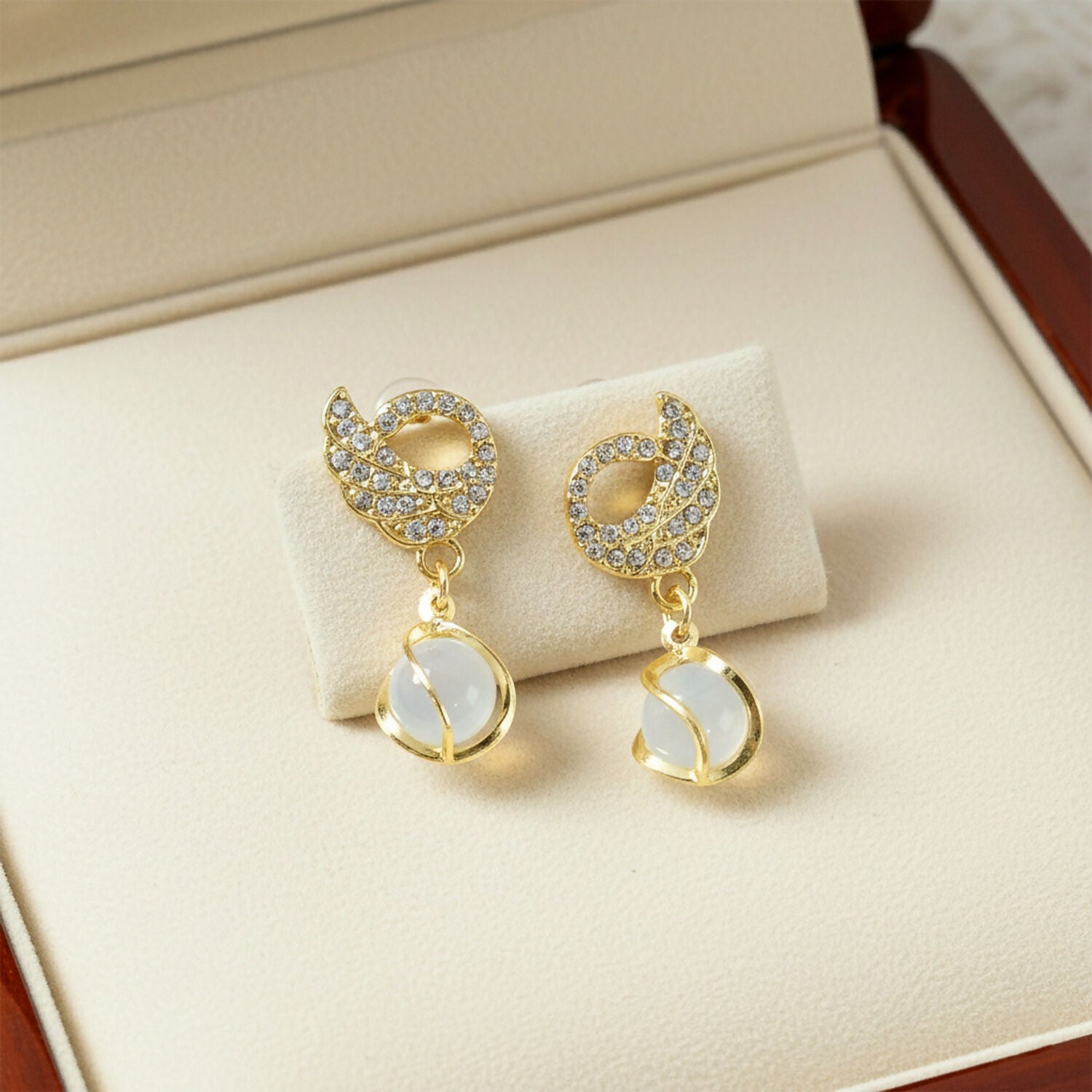 Crystal encrusted swan earrings with cat-eye stone drop front view